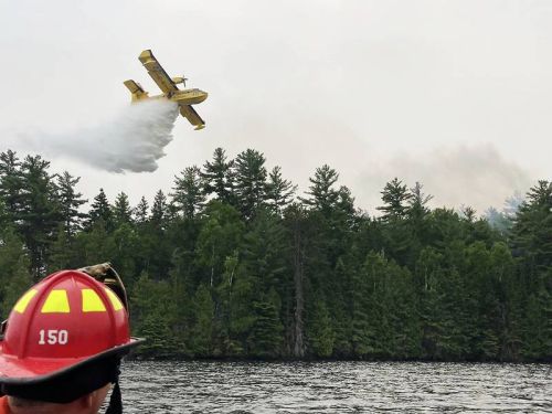 A water bomber drops its payload on the Centennial Lake fire.